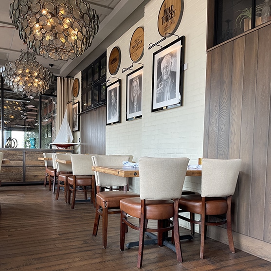 Square photo showing a dining area at the pearl dublin with large chandeliers and a wooden floor