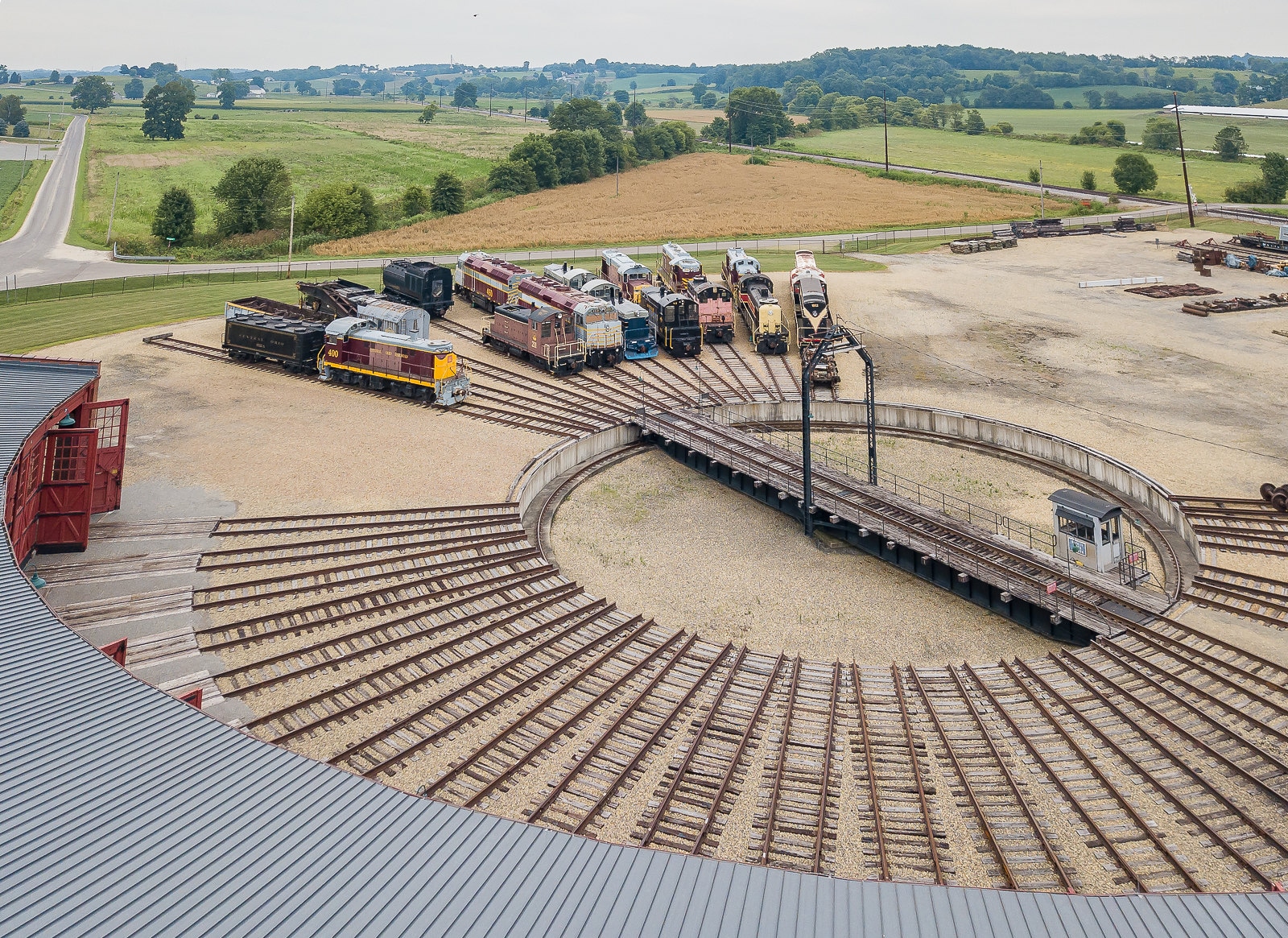 horizontal photo of the age of steam roundhouse. A large, circular turntable to move trains from one track to another with fields in the background Image credit: Terry Redeker on Flickr