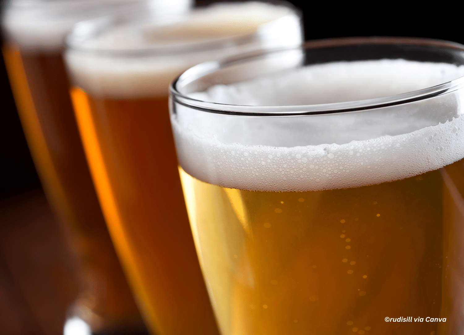 horizontal photo of a close up shot of three glasses of beer on a bar