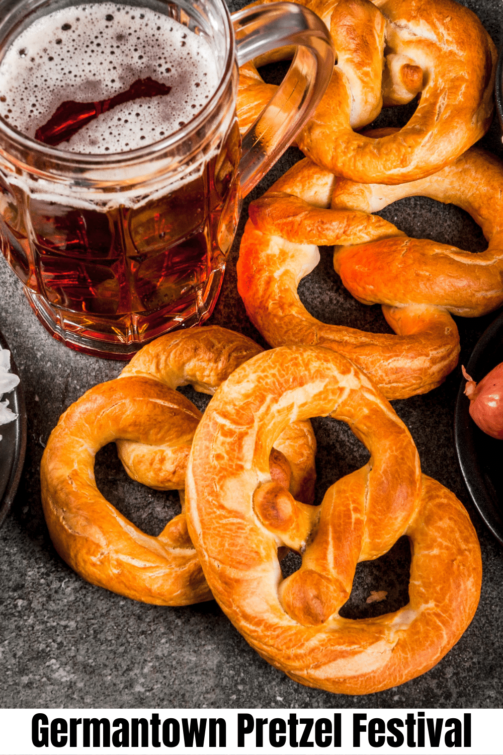 vertical image for pinterest with a photo of three soft pretzels with salt sprinkled on them. On a wooden surface with a clear glass of beer. A white strip at the top has the text Germantown Pretzel Festival 