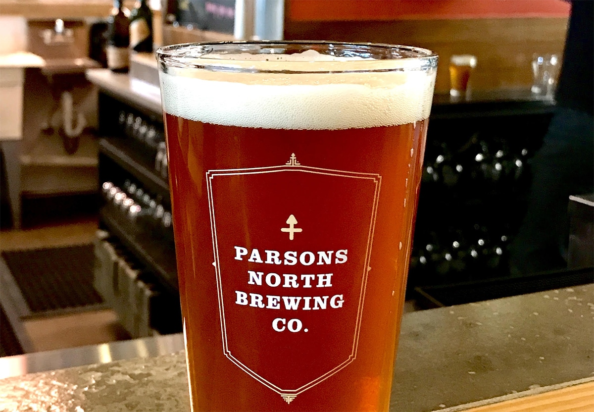horizontal photo of a pint of beer with the Parsons North Brewing Co logo on the front