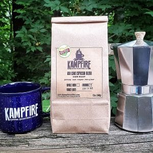 square photo of a bag of kampfire coffee ash cave espresso blend, with a blue mug with the kampfire logo and a coffee pot. Image courtesy of Kampfire Coffee Roasters