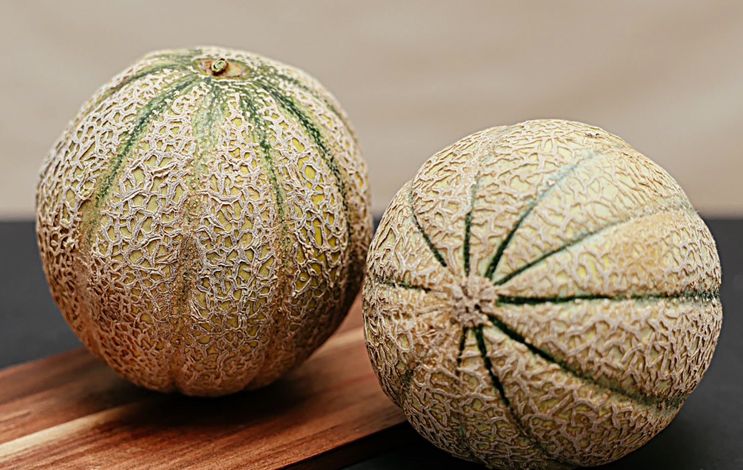 horizontal photo of 2 cantaloupe melons on a wooden cutting board. Image credit https://www.pexels.com/photo/melons-on-a-wooden-chopping-board-7657268/