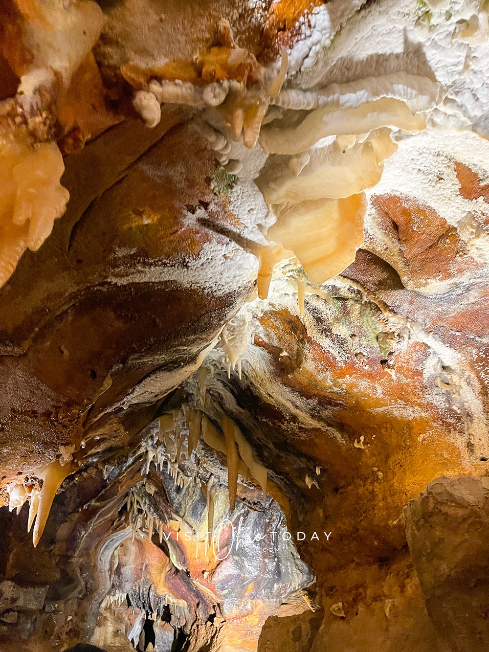 vertical photo of a tunnel in the ohio caverns with small stalactites from the top