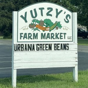 square photo showing the yutzi's farm market hoarding, advertising urbana green beans