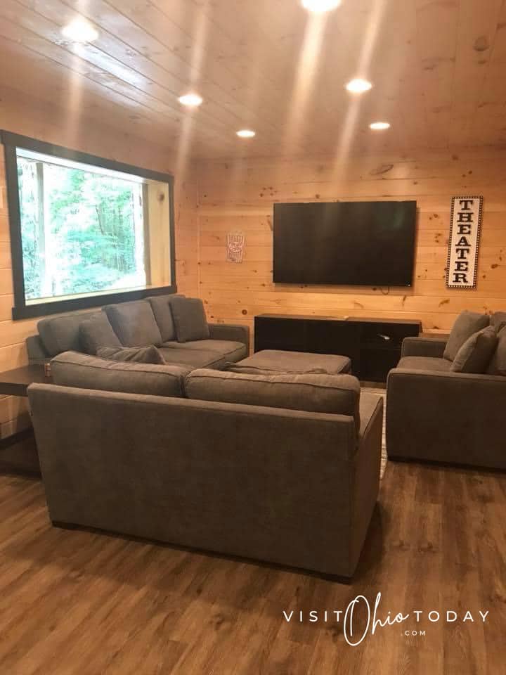 theater room with large tv and couches