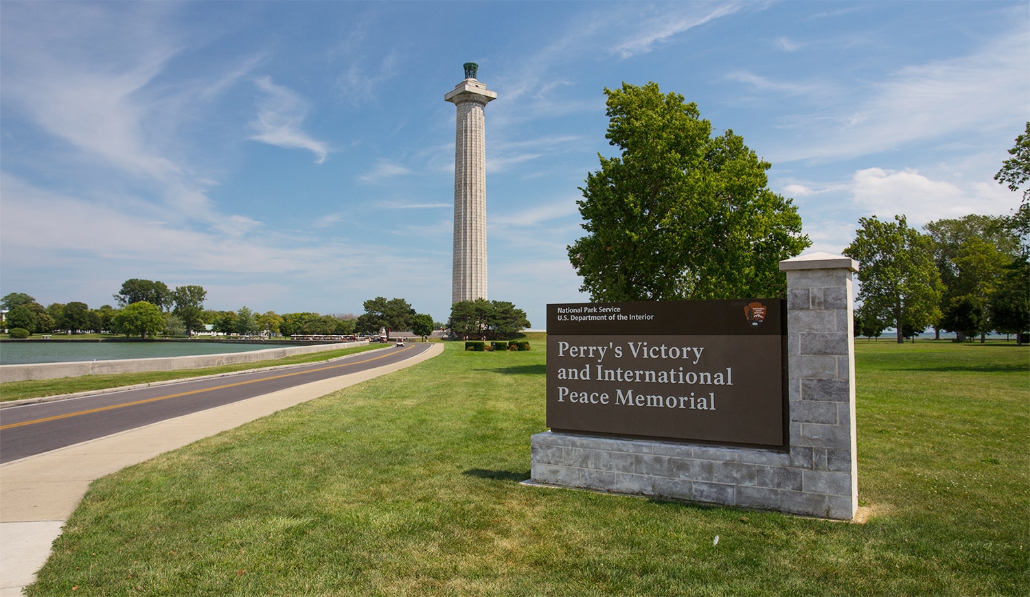 horizontal photo of perry's Victory and International Peace Memorial with the name sign in the foreground and the memorial in the background. Image via Canva pro license