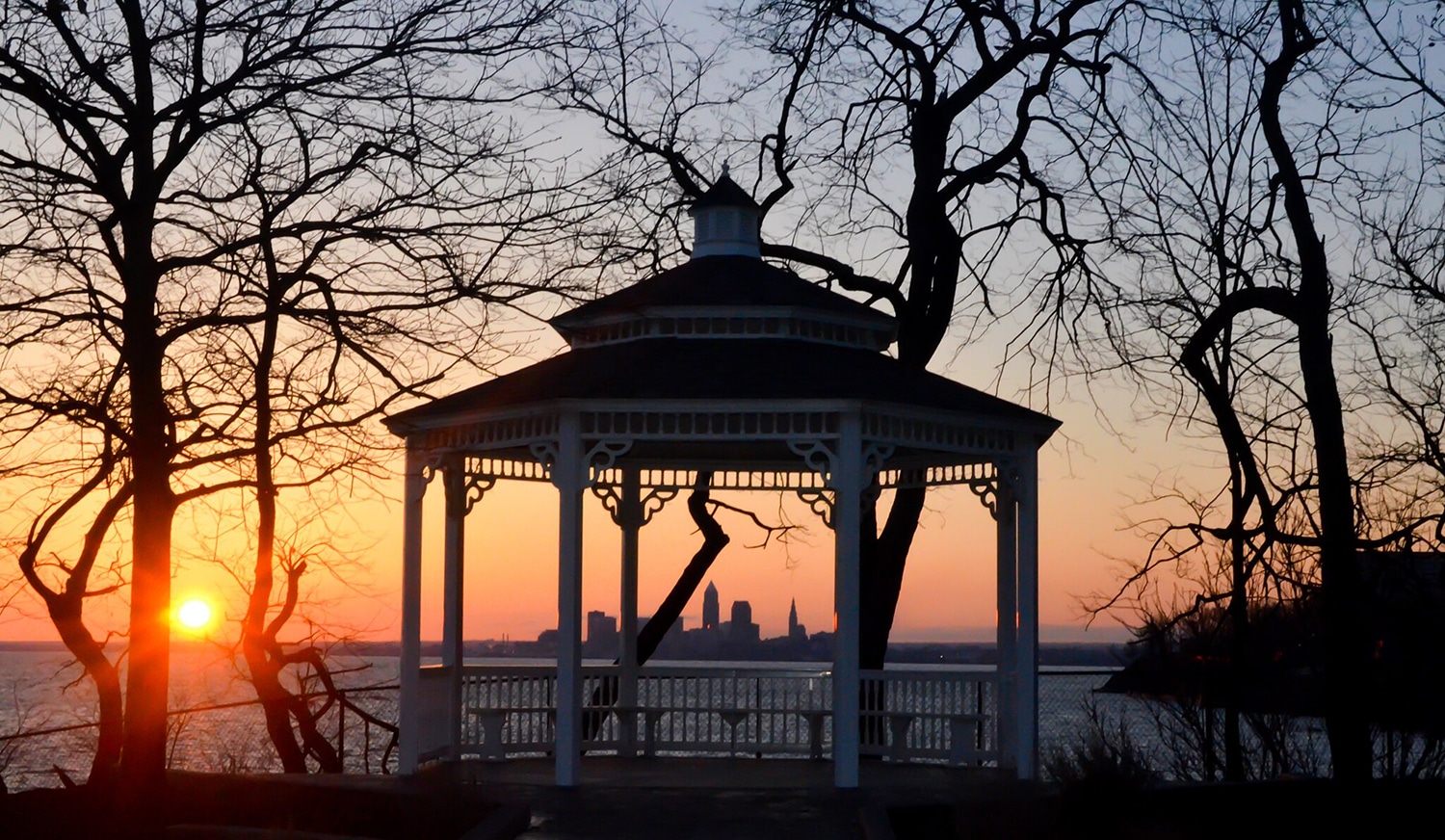 horizontal photo of a pavilion and trees at Lakewood Park at sunrise. Image via Wikimedia Commons