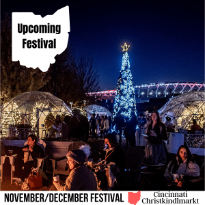 square image with a photo of the lit Christmas tree a Christkindlmarkt with igloos and a lit building in the background and people in the foreground. A white strip across the bottom has the text November/December Festival Christkindlmarkt. Image courtesy of Christkindlmarkt