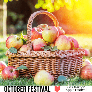 square image with a photo of a basket of apple on the grass, with a few apples on the ground. A white strip at the bottom has the text October Festival Oak Harbor Apple Festival. Image via Canva pro license