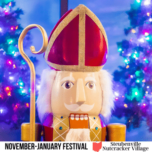 square image with a photo of St Nicholas Nutcracker with two lit christmas trees in the background. A white strip across the bottom has the text November-January Festival Steubenville Nutcracker Village. Image courtesy of Steubenville Nutcracker Village