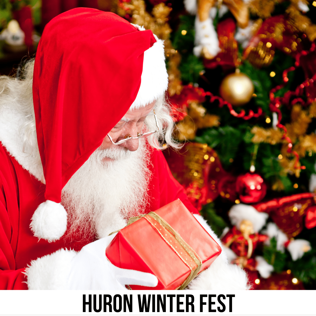square image with a photo of Santa beside a decorated Christmas tree with a gift in his hands. A white strip across the bottom has the text Huron Winter Fest