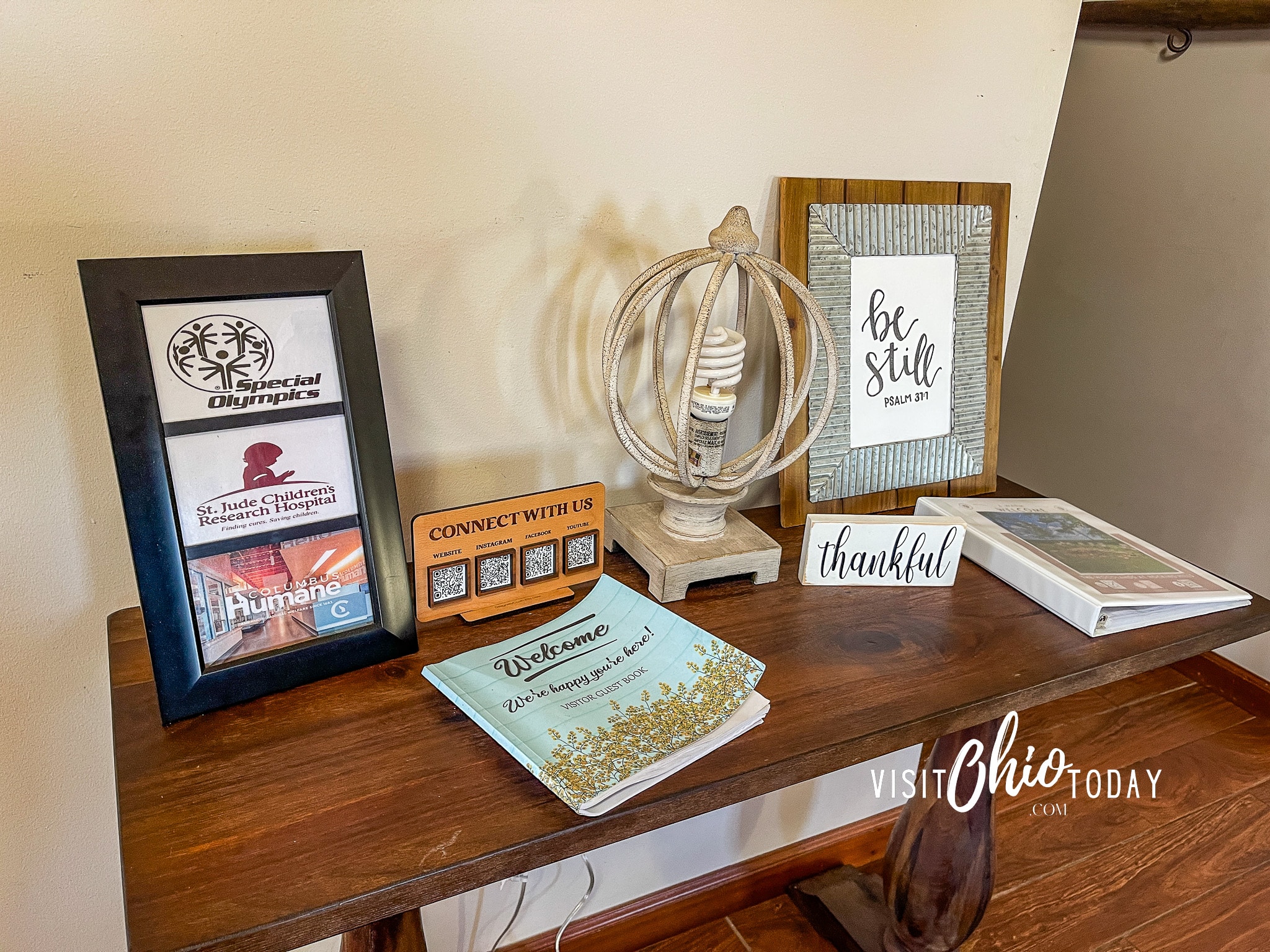 table of welcome book, guest book, decor and a photo of the three charities for woodlands lodge Photo Credit Cindy Gordon of VisitOhioToday.com