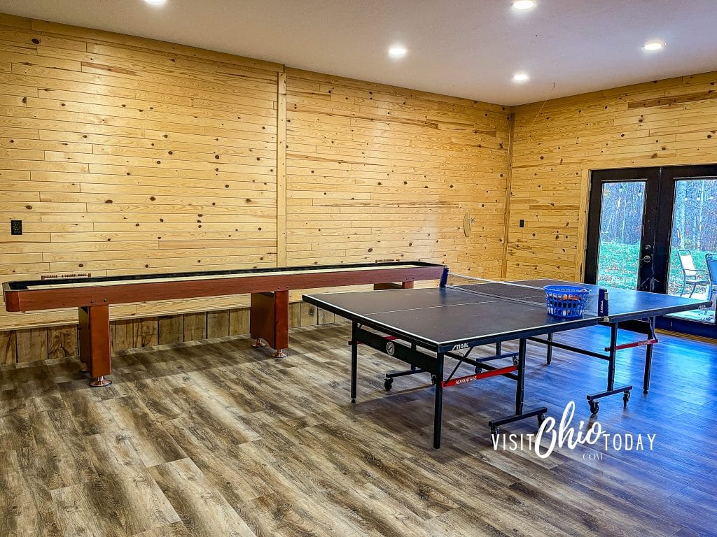 wooden walls in a game room at woodlands lodge, shown is a ping pong table and a hand shuffle board table Photo Credit Cindy Gordon of VisitOhioToday.com