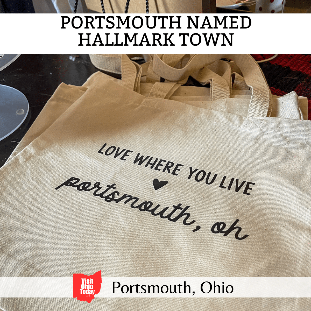 square image with a photo of a small pile of white shopping bags with Love where you Live, Portsmouth Oh, printed on them. A white strip across the top has the text Portsmouth Named Hallmark Town
