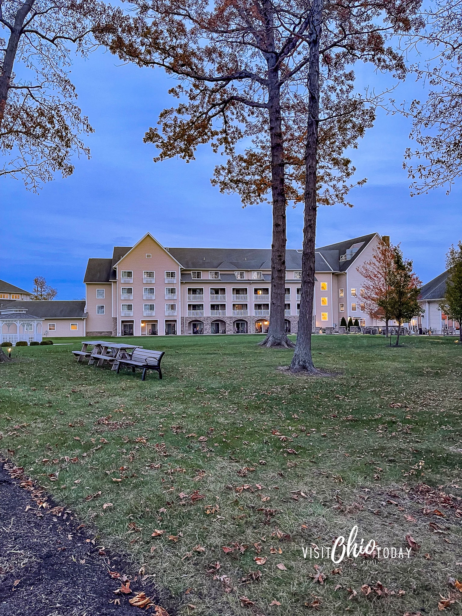 vertical photo of the Lodge at Geneva-on-the-Lake with a grassy area and trees in the foreground