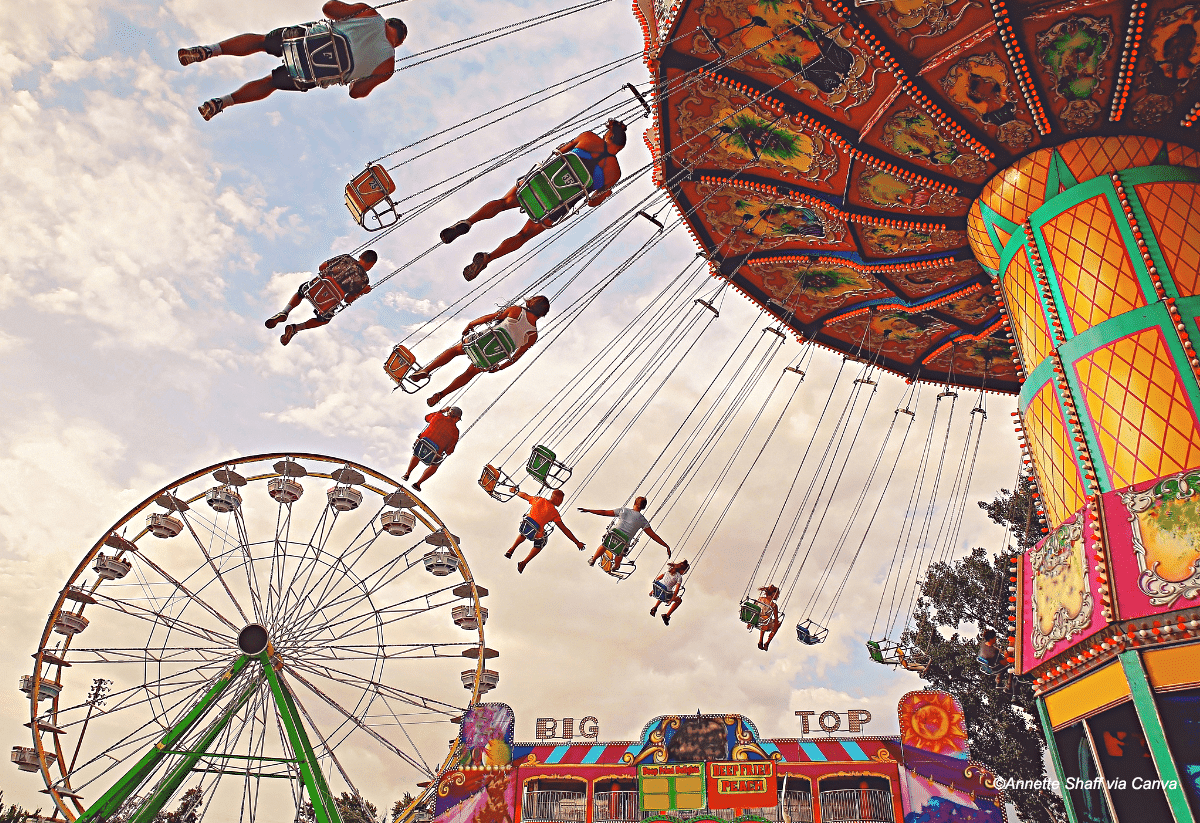 horizontal photo of people on a swing carousel at a fairground
