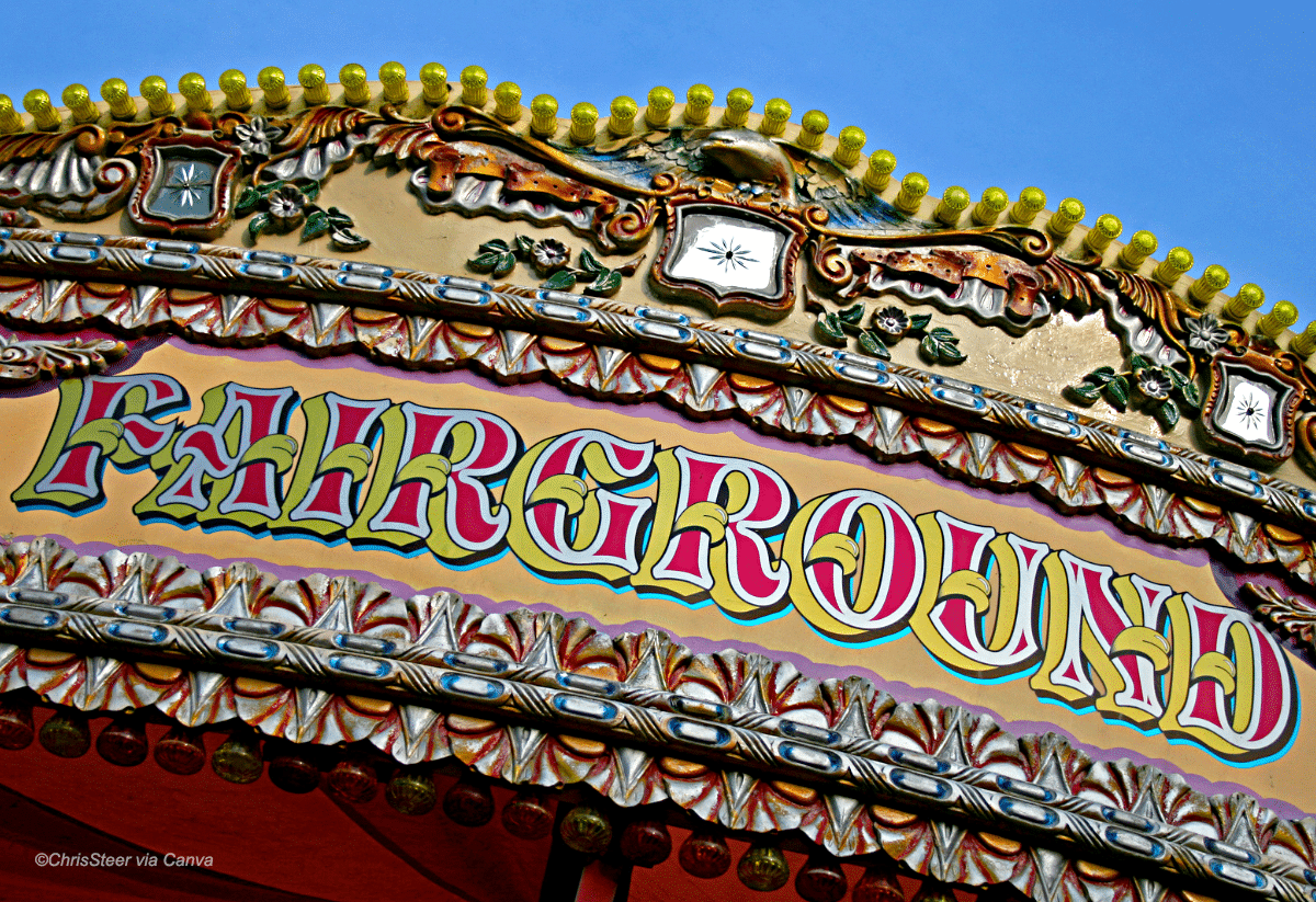 horizontal photo of the top of a carousel with the word Fairground across it.