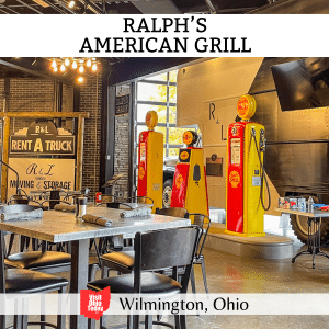 square image with a photo of the inside of Ralph's American Grill with vintage gasoline pumps in the background. A white strip across the top has the text Ralph's American Grill, and a white strip across the bottom has the text Wilmington, Ohio