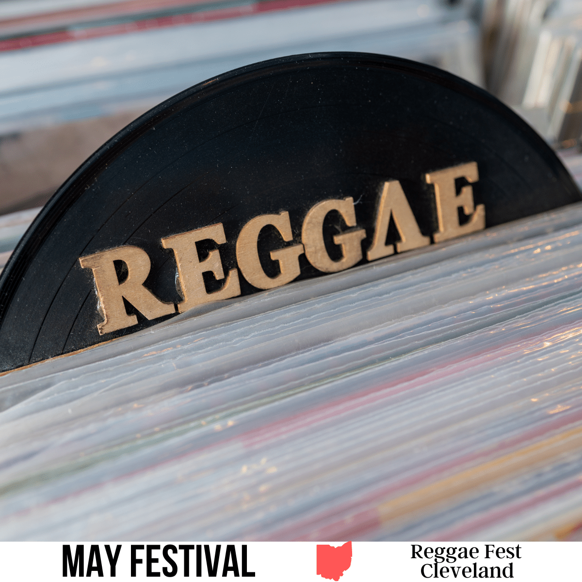 A square image of a photo of an organizer sign that has text Reggae in gold letters on a black background. A white strip across the bottom has text May Festival Reggae Fest Cleveland.