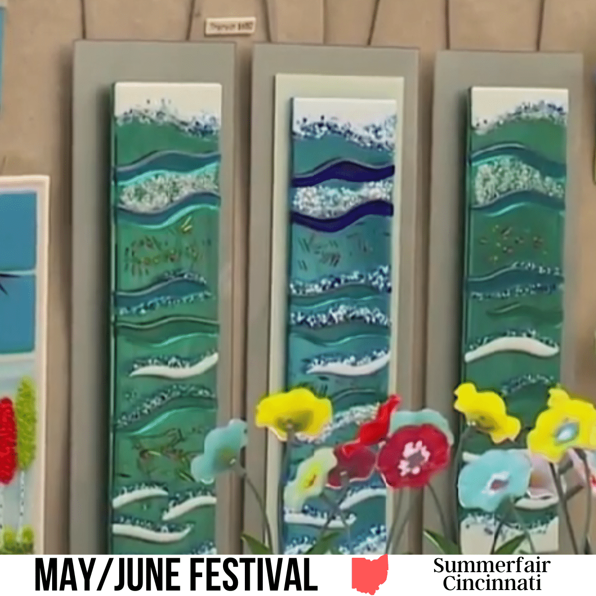 A square image of a photo of a drawing of 3 pieces of framed art on a wall with colorful flowers in front of it. A white strip across the bottom has text May/June Festival Summerfair Cincinnati.