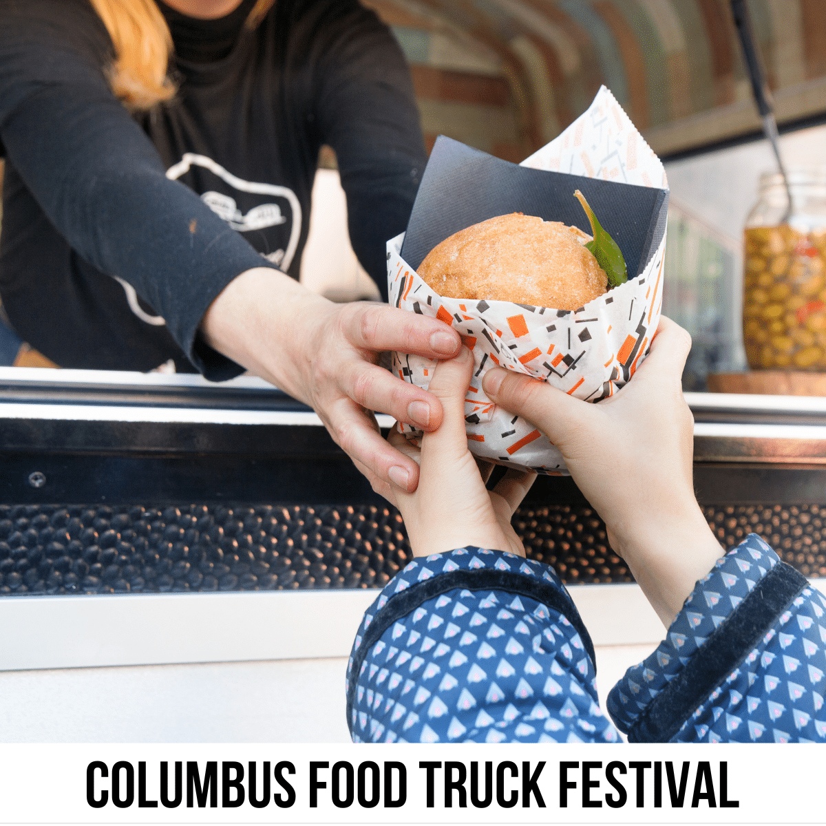 A square image of a close up photo of someone handing another person food at a food truck. A white strip across the bottom has text Columbus Food Truck Festival. 