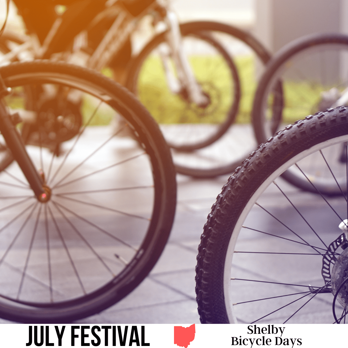 A square image of a close-up photo of wheels on bicycles. A white strip across the bottom has text July Festival Shelby Bicycle Days.