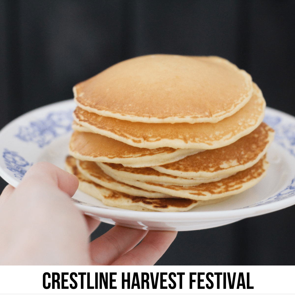 square image with a photo of a hand holding a plate with a pile of pancakes on it. A white strip at the bottom has the text Crestline Harvest Festival