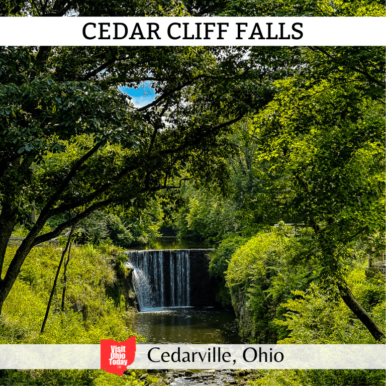 square image with a photo of Cedar Cliff Falls looking through tree foliage. A white strip across the top contains the text Cedar Cliff Falls, and a white strip across the bottom has the text Cedarville, Ohio