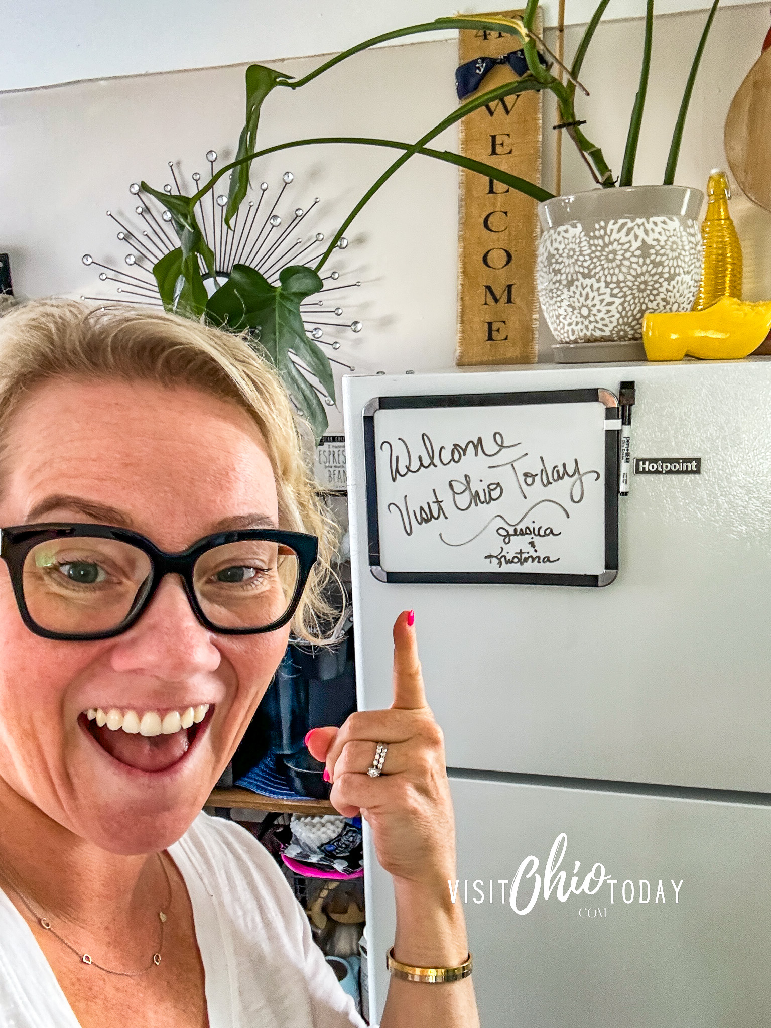 vertical photo of Cindy Gordon pointing at a welcome note on a door. Photo credit: Cindy Gordon of VisitOhioToday.com