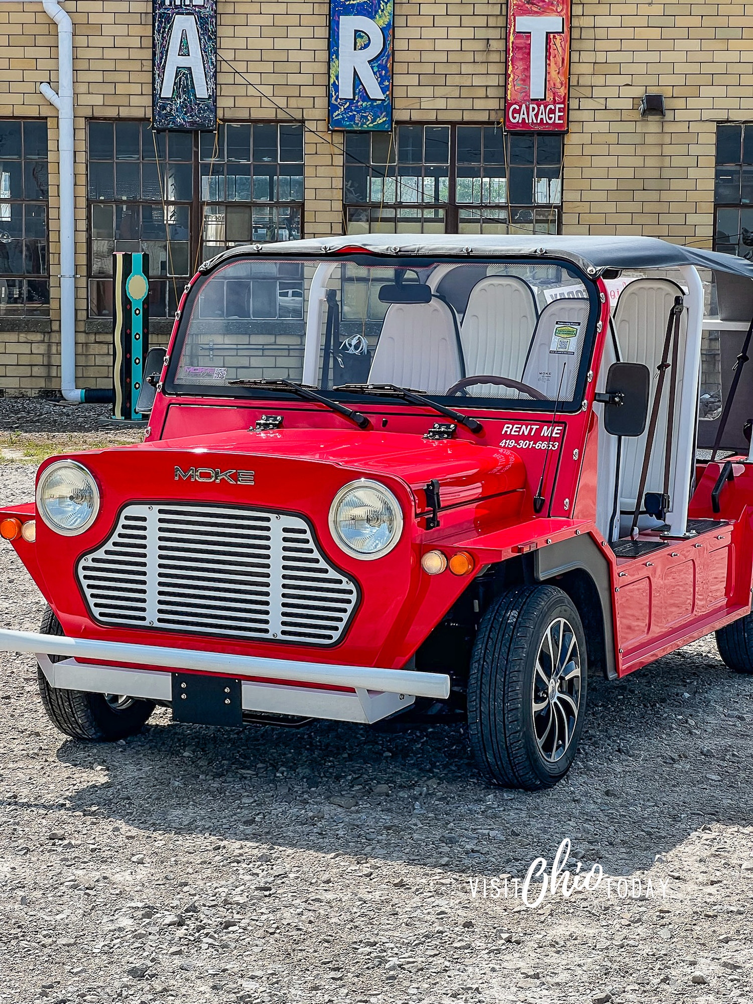 vertical photo of a red Moke parked in front of the Art Garage in Port Clinton Ohio. Photo credit: Cindy Gordon of VisitOhioToday.com