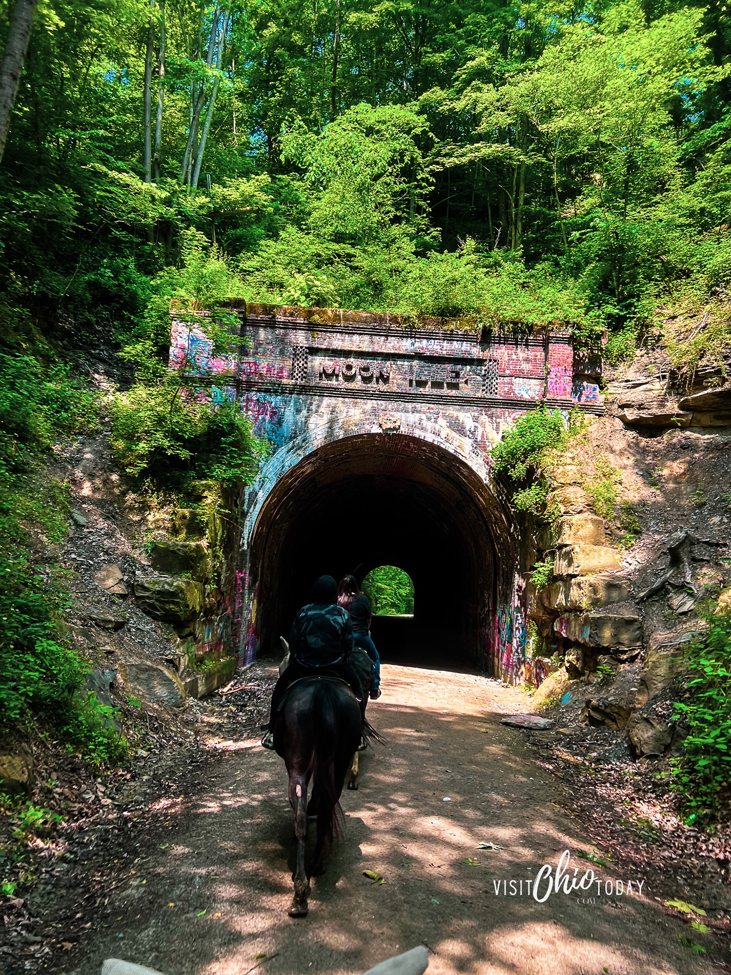 vertical photo of two horseback riders heading toward Moonville Tunnel. Photo credit: Cindy Gordon of VisitOhioToday.com