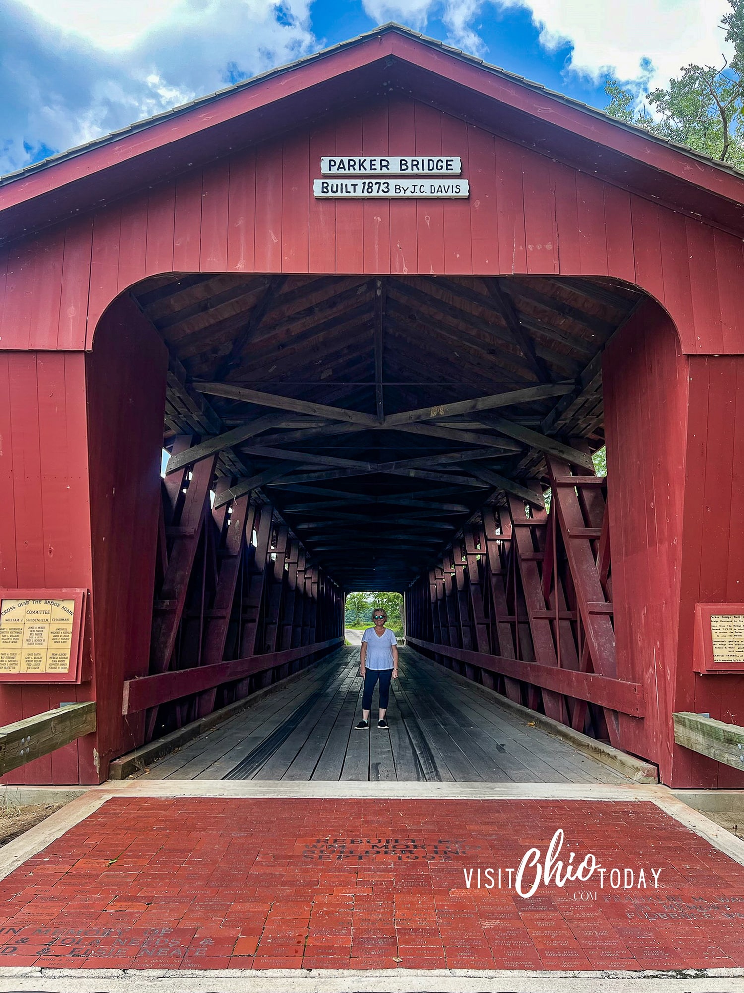 vertical photo of Parker Bridge in Upper Sandusky with Cindy Gordon standing just inside it. Photo credit: Cindy Gordon of VisitOhioToday.com