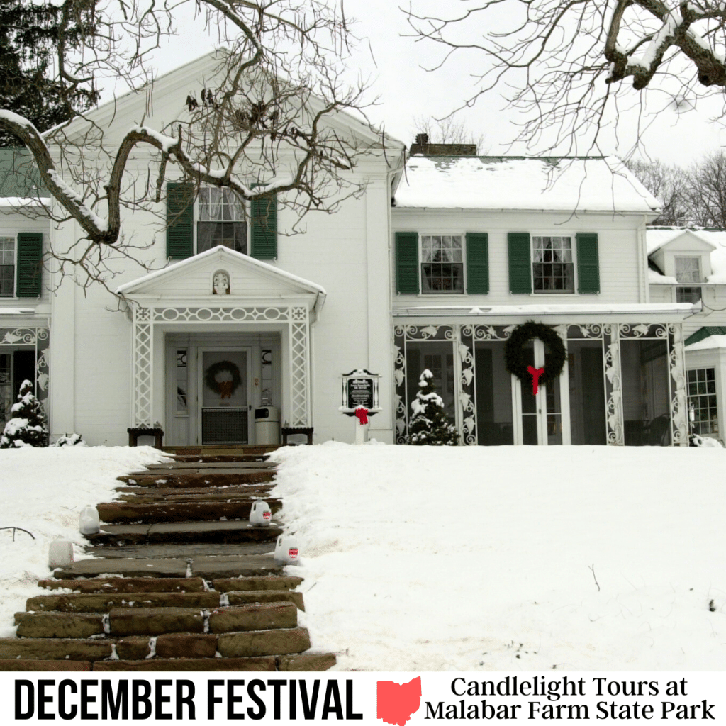 A square image of a photo of a white house with green shutters, adorned with holiday wreaths. Steps lead up to the house, and the grass on either side of the steps is covered in snow. A white strip across the bottom has text December Festival Candlelight Tours at Malabar Farm State Park.