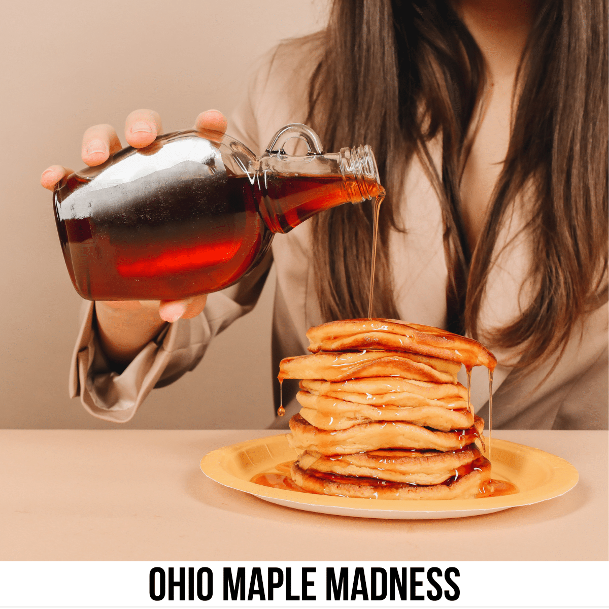 square image with a photo of a woman pouring maple syrup on to a pile of pancakes. A white strip across the bottom has the text Ohio Maple Madness