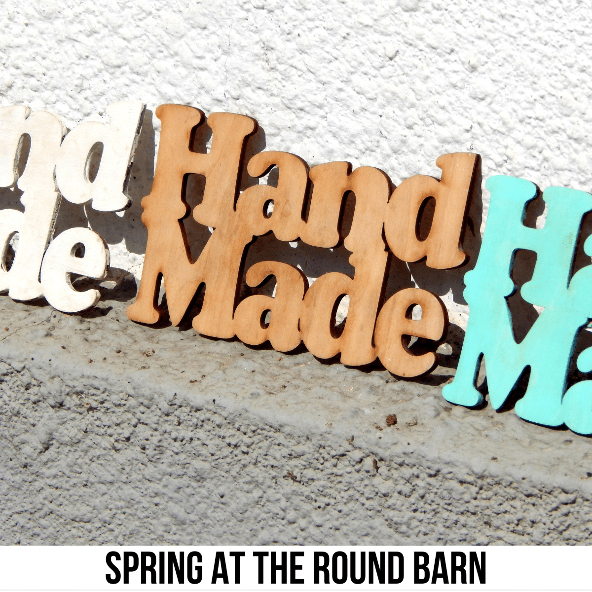 square image with wood carvings of the words 'hand made'. A white strip across the bottom has the text Spring at the Round Barn