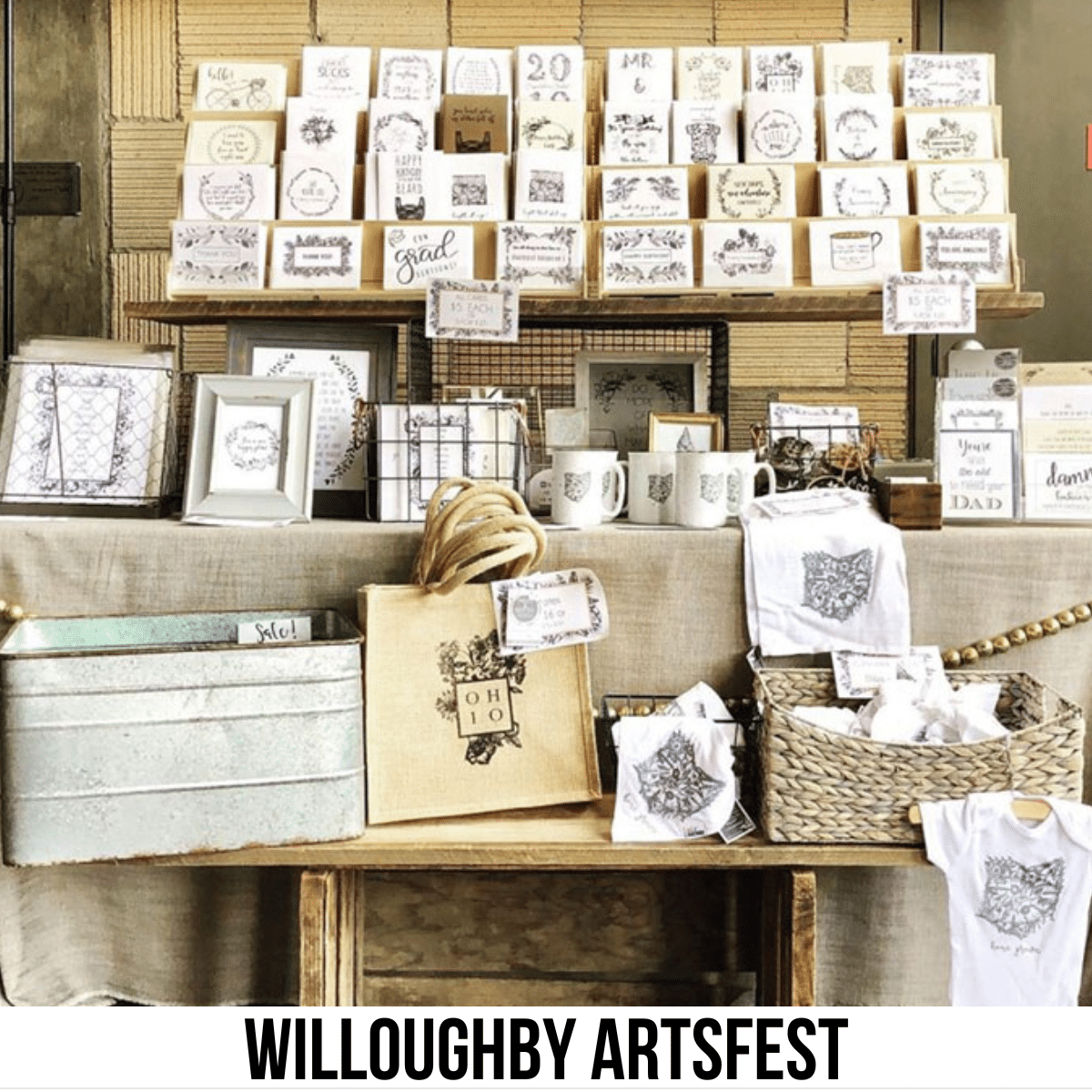 square image with a photo of an arts and crafts stall with plaques, shopping bags, cards and more, all Ohio-related. A white strip across the bottom has the text Willoughby ArtsFest