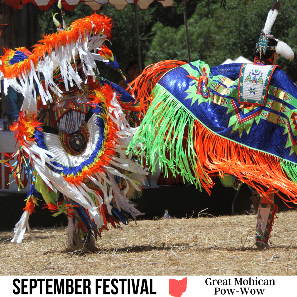 square image with a photo of two people in full native American costume at a pow-wow. A white strip across the bottom has the text September Festival. Great Mohican Pow-Wow